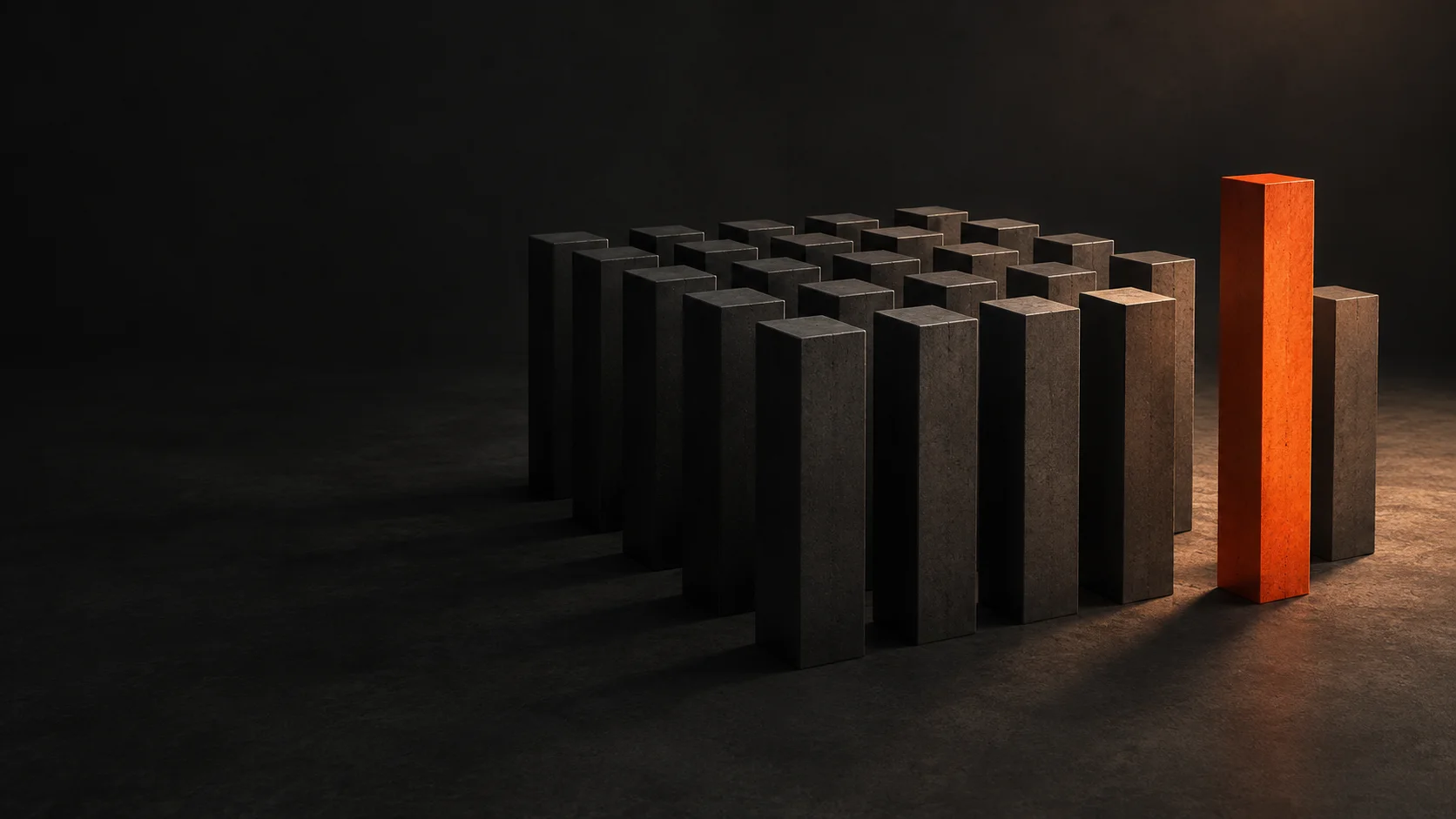 A single orange pillar stands apart from rows of graphite pillars.